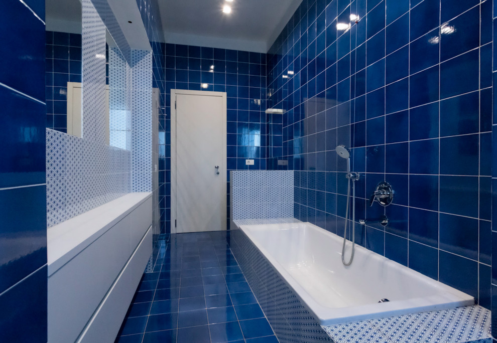 ミラノにある広いコンテンポラリースタイルのおしゃれなマスターバスルーム (フラットパネル扉のキャビネット、白いキャビネット、ドロップイン型浴槽、分離型トイレ、青いタイル、セラミックタイル、白い壁、セラミックタイルの床、オーバーカウンターシンク、タイルの洗面台、赤い床、青い洗面カウンター、洗面台1つ、造り付け洗面台) の写真