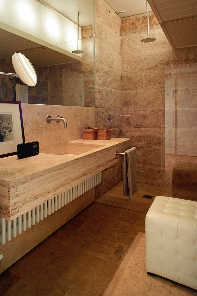 Cette image montre une salle de bain design de taille moyenne avec des dalles de pierre, un sol en marbre, un lavabo intégré et un plan de toilette en marbre.