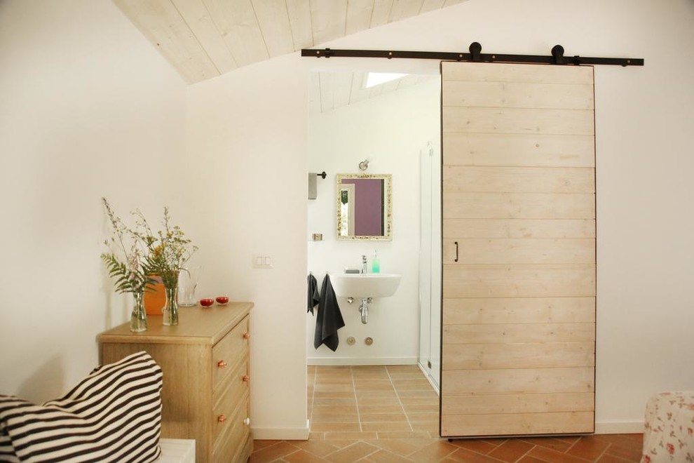 Foto de cuarto de baño campestre con paredes blancas, lavabo suspendido y suelo marrón