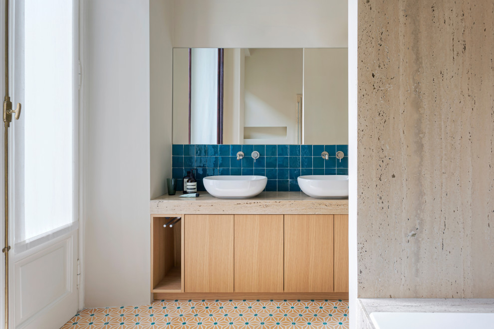 Inredning av ett modernt beige beige badrum, med släta luckor, skåp i ljust trä, blå kakel, vita väggar, mörkt trägolv, ett fristående handfat och flerfärgat golv