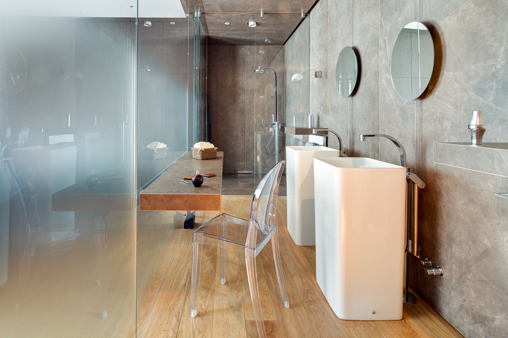 Imagen de cuarto de baño actual con ducha a ras de suelo, suelo de madera en tonos medios, aseo y ducha y lavabo con pedestal