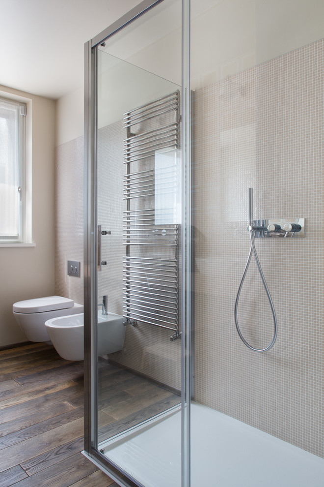 Immagine di una stanza da bagno con doccia minimal con doccia ad angolo, WC sospeso, piastrelle beige, piastrelle a mosaico, pareti beige e parquet scuro