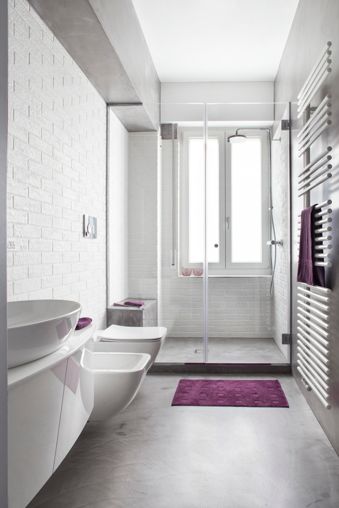 Idéer för att renovera ett mellanstort industriellt badrum med dusch, med släta luckor, vita skåp, en dusch i en alkov, en vägghängd toalettstol, vit kakel, tunnelbanekakel, grå väggar, betonggolv, ett fristående handfat och dusch med gångjärnsdörr