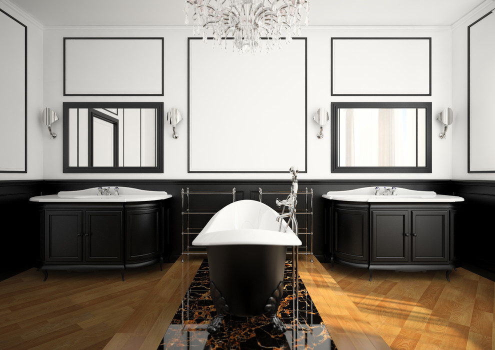 Стильный дизайн: огромная главная ванная комната в классическом стиле с фасадами с утопленной филенкой, черными фасадами, ванной на ножках, паркетным полом среднего тона, монолитной раковиной, белыми стенами и зеркалом с подсветкой - последний тренд