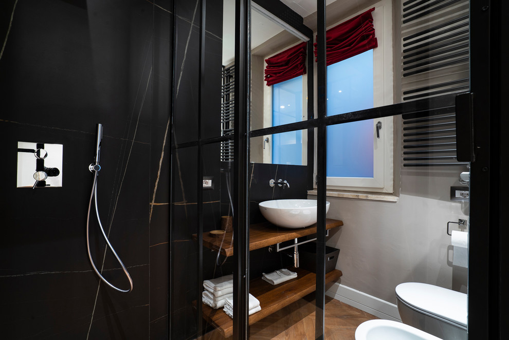 Esempio di una stanza da bagno design con doccia ad angolo, bidè, piastrelle nere, pareti grigie, lavabo a bacinella, top in legno, pavimento marrone e top marrone