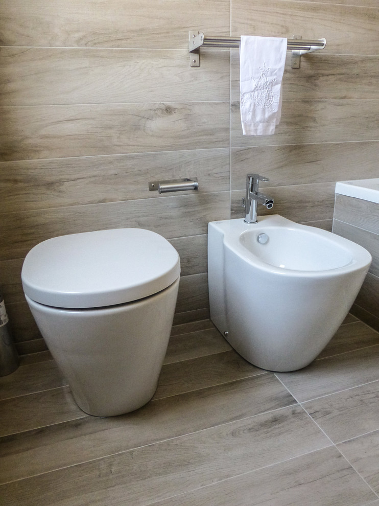 Aménagement d'une petite salle de bain moderne avec une baignoire encastrée, WC séparés, un carrelage marron, des carreaux de porcelaine, un mur beige, un sol en carrelage de porcelaine et un sol marron.