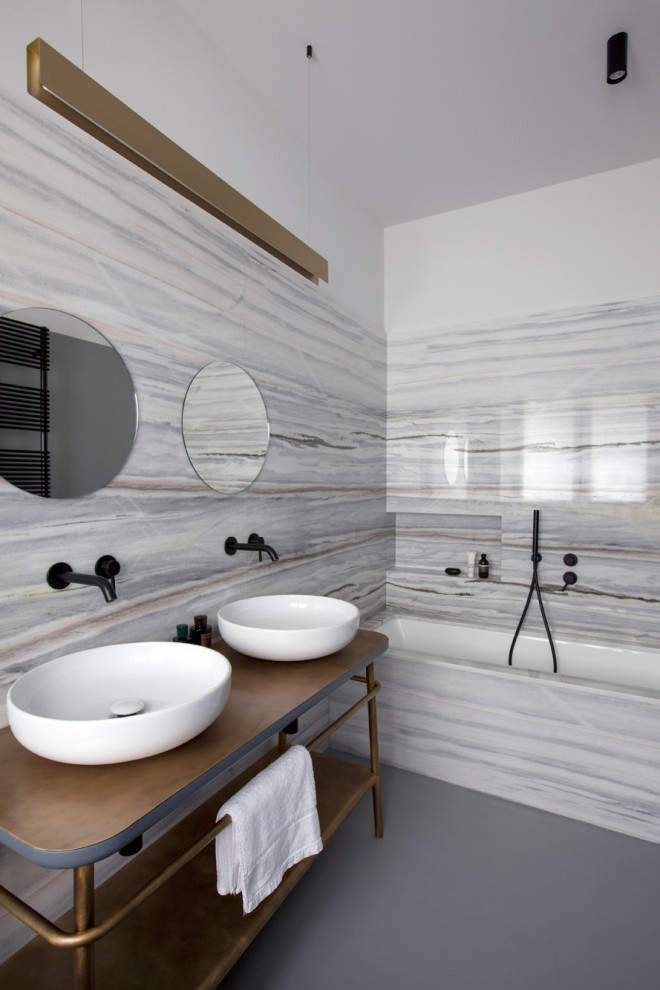 Modelo de cuarto de baño doble y de pie contemporáneo con bañera empotrada, baldosas y/o azulejos grises, paredes blancas, lavabo sobreencimera, encimera de laminado, suelo gris, encimeras marrones y hornacina