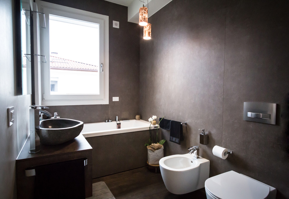 Exemple d'une salle de bain principale tendance de taille moyenne avec une baignoire posée, un bidet, un mur marron, parquet foncé et une vasque.