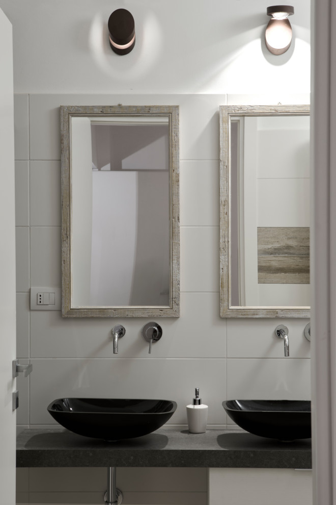 Свежая идея для дизайна: ванная комната в современном стиле с белой плиткой, настольной раковиной и черной столешницей - отличное фото интерьера