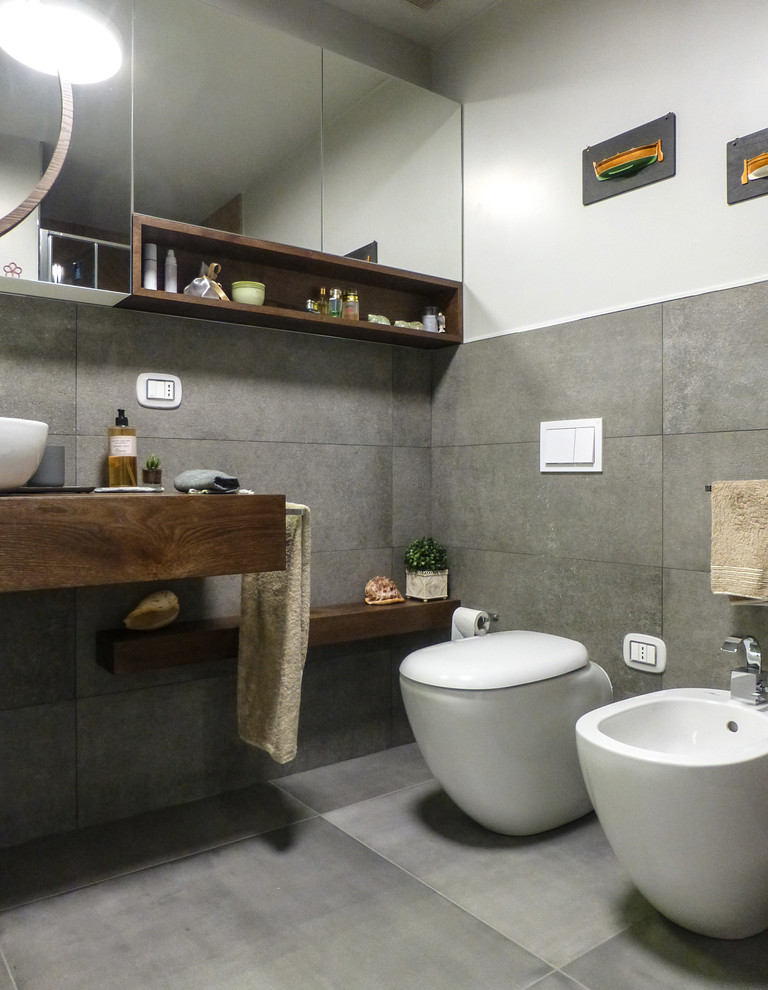 Inspiration pour une salle de bain design de taille moyenne avec WC séparés, un carrelage gris, des carreaux de porcelaine, un mur blanc, un sol en carrelage de porcelaine, une vasque, un plan de toilette en stratifié, un sol gris et une cabine de douche à porte battante.