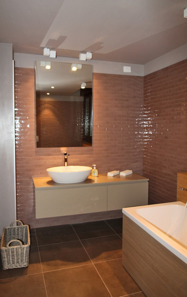 Photo of a medium sized modern bathroom in Bologna with flat-panel cabinets, beige cabinets, a built-in bath, a two-piece toilet, ceramic tiles, ceramic flooring, a vessel sink, wooden worktops, brown floors and beige worktops.