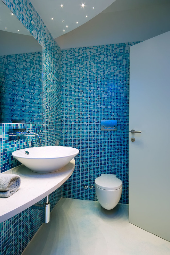 Ispirazione per una piccola stanza da bagno contemporanea con WC sospeso, piastrelle blu, piastrelle a mosaico e lavabo a bacinella