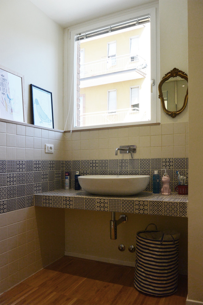 Idéer för små funkis badrum med dusch, med skåp i ljust trä, en toalettstol med separat cisternkåpa, flerfärgad kakel, porslinskakel, vita väggar, ljust trägolv, ett fristående handfat och kaklad bänkskiva