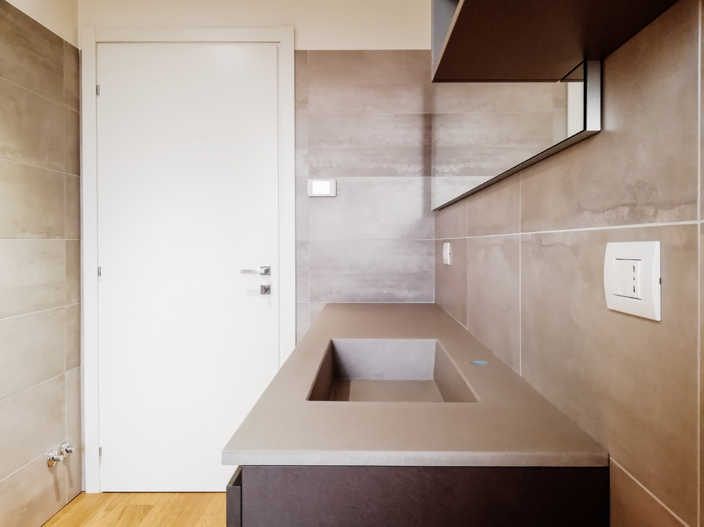 Immagine di una grande stanza da bagno minimalista con ante lisce, piastrelle in gres porcellanato, top in superficie solida e ante grigie