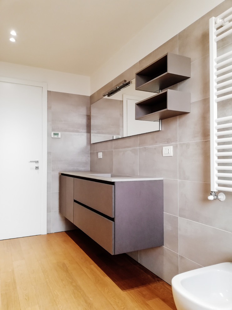 Großes Modernes Badezimmer mit flächenbündigen Schrankfronten, Porzellanfliesen und grauen Schränken in Mailand