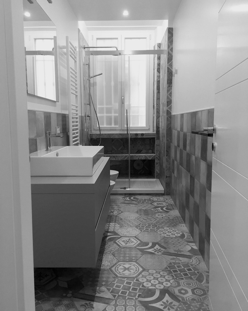 На фото: маленькая ванная комната в современном стиле с серыми фасадами, душем в нише, инсталляцией, керамогранитной плиткой, белыми стенами, полом из керамогранита, душевой кабиной, настольной раковиной, столешницей из ламината, разноцветным полом и душем с раздвижными дверями для на участке и в саду с