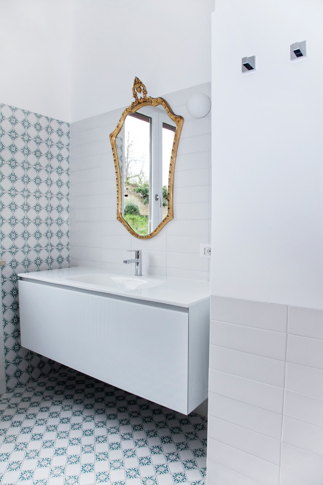 Immagine di una stanza da bagno contemporanea con ante lisce, ante bianche, lavabo da incasso e top bianco
