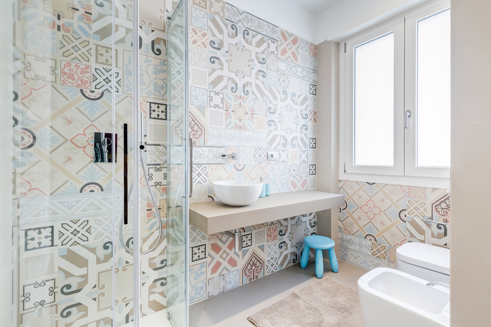 Modern inredning av ett mellanstort beige beige badrum med dusch, med en kantlös dusch, en bidé, keramikplattor, dusch med skjutdörr, flerfärgad kakel, beige väggar, ett fristående handfat och grått golv
