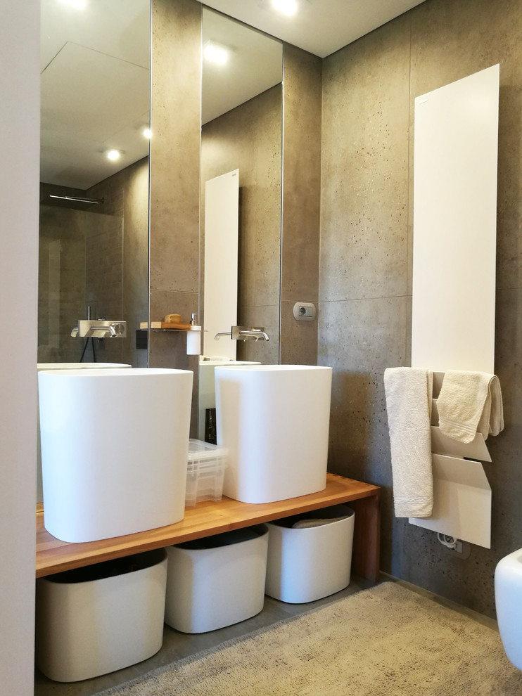 Aménagement d'une salle de bain contemporaine de taille moyenne avec un mur gris, une vasque, un plan de toilette en bois et un sol gris.