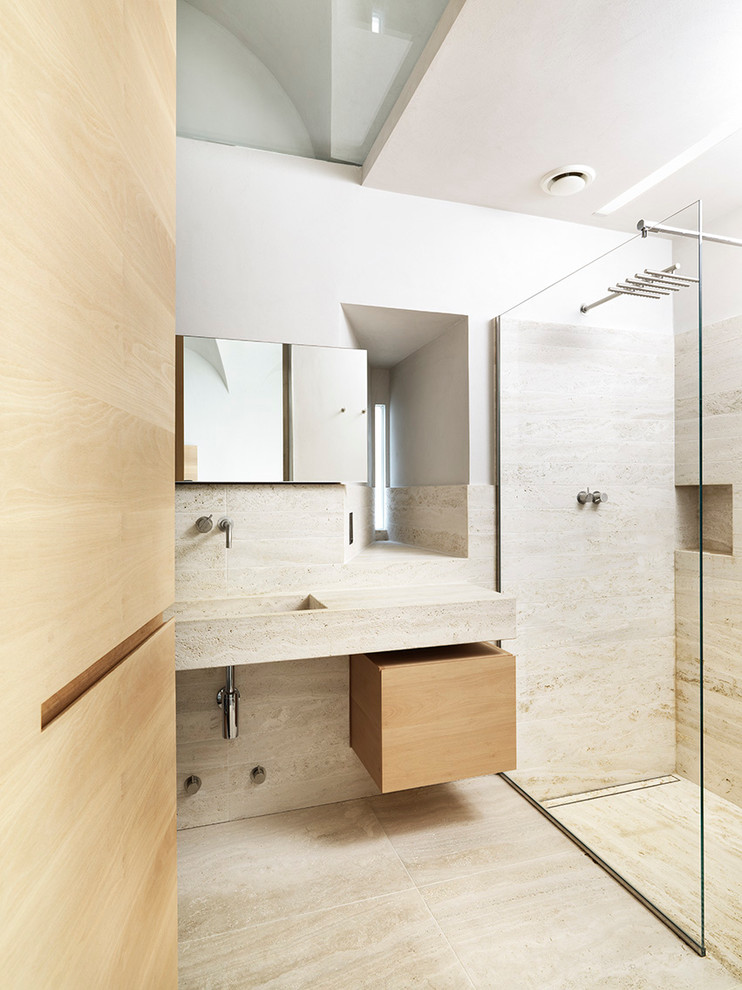 Идея дизайна: ванная комната среднего размера в современном стиле с плоскими фасадами, светлыми деревянными фасадами, душем без бортиков, полом из травертина, душевой кабиной, монолитной раковиной и плиткой из листового камня