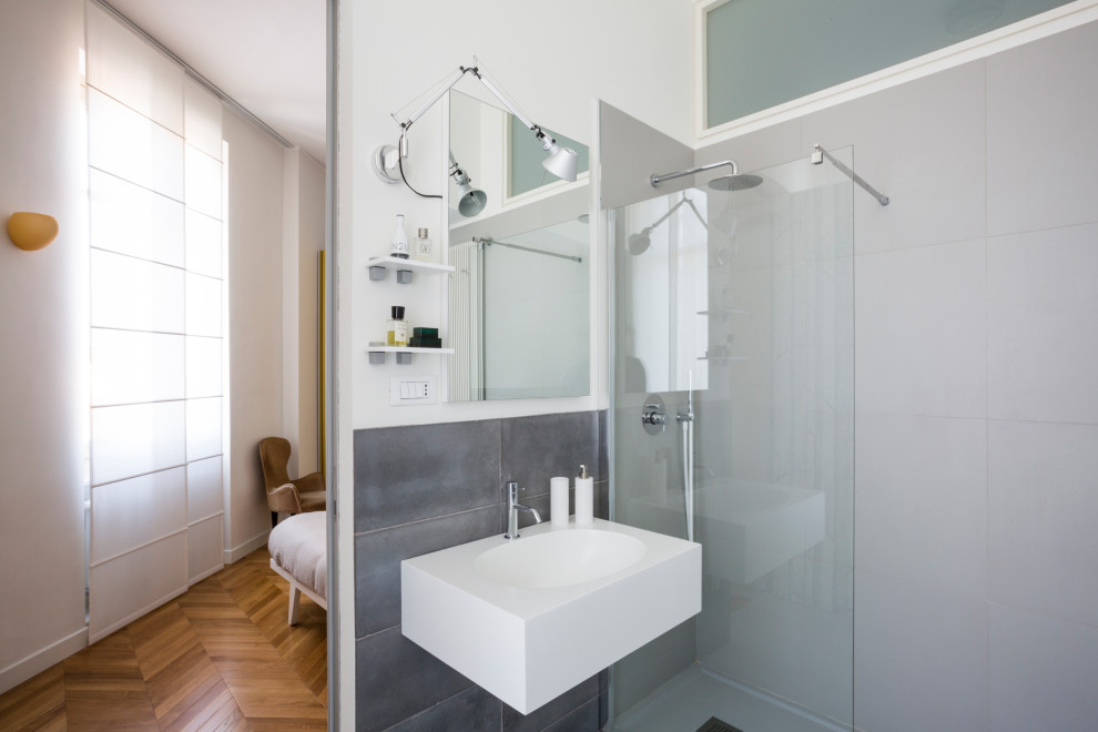 Exempel på ett mellanstort modernt en-suite badrum, med en kantlös dusch, grå kakel, vita väggar, klinkergolv i porslin, ett väggmonterat handfat och grått golv