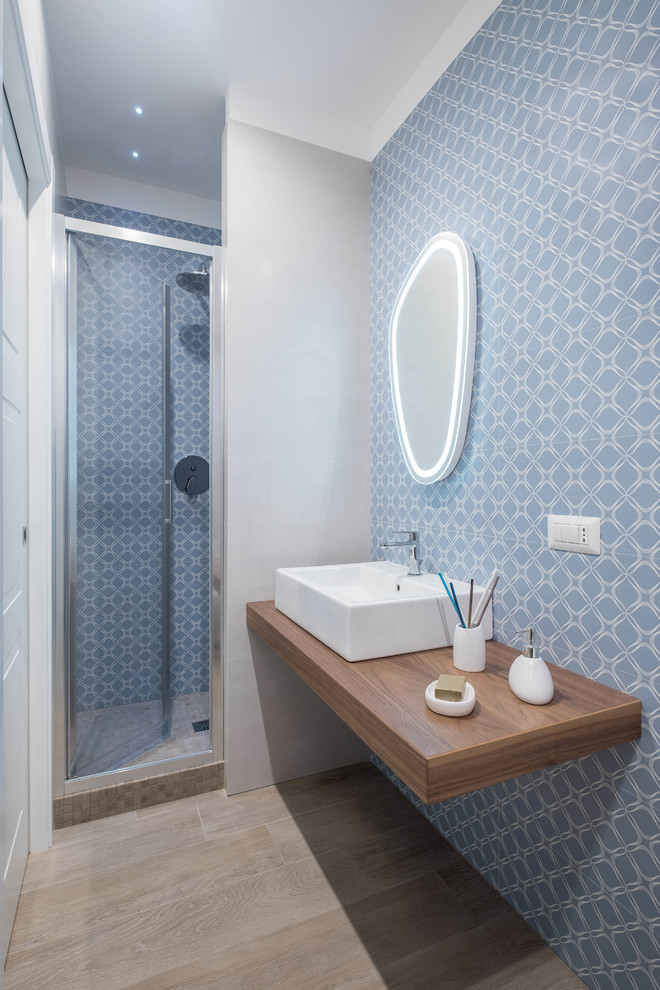 Inspiration pour une petite salle de bain design avec un carrelage bleu, un carrelage multicolore, un carrelage blanc, une vasque, un plan de toilette en bois, une cabine de douche à porte battante, un mur multicolore, parquet clair et un plan de toilette marron.