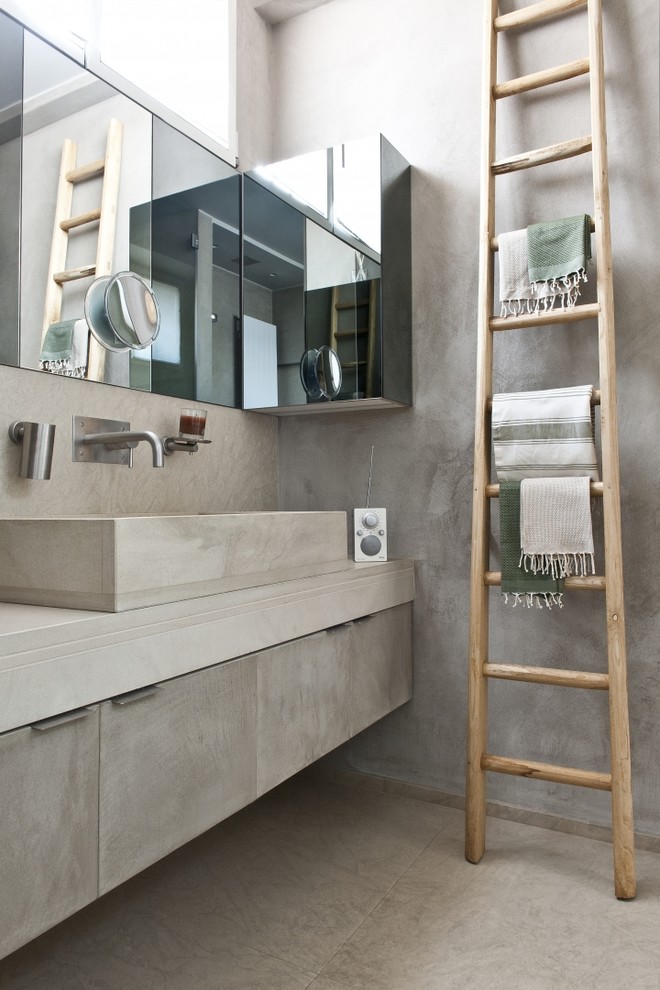 Ejemplo de cuarto de baño actual con paredes grises, armarios con paneles lisos y puertas de armario grises