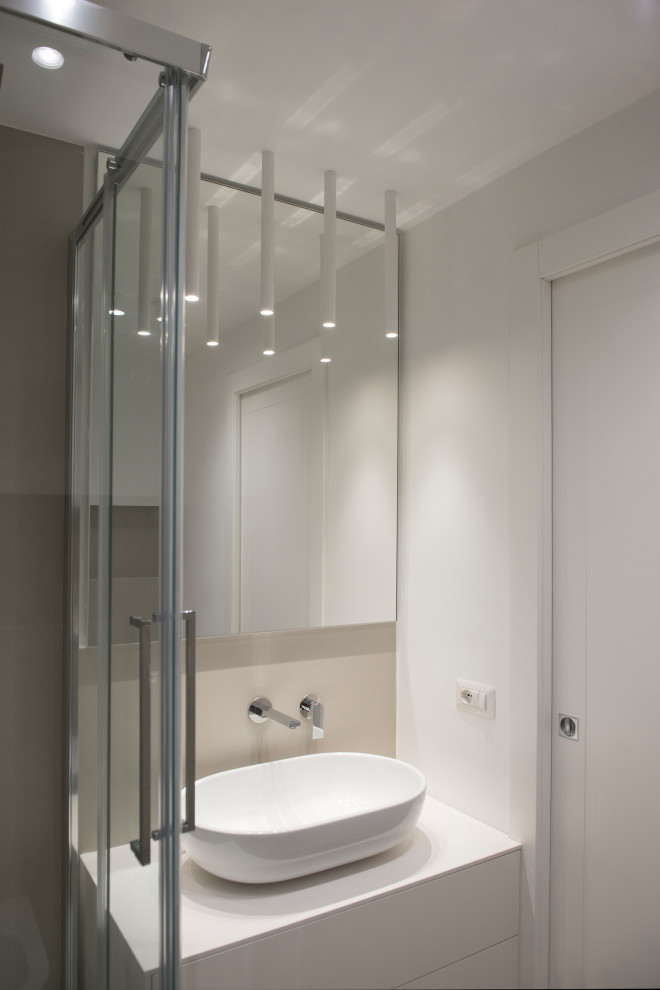 This is an example of a small bathroom in Rome with flat-panel cabinets, white cabinets, a two-piece toilet, white tiles, porcelain tiles, a vessel sink, laminate worktops, white worktops, a corner shower, white walls, porcelain flooring, blue floors and a sliding door.