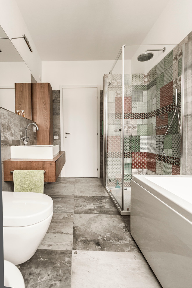Exempel på ett modernt badrum, med en hörndusch, en vägghängd toalettstol, stenhäll, vita väggar och ett fristående handfat