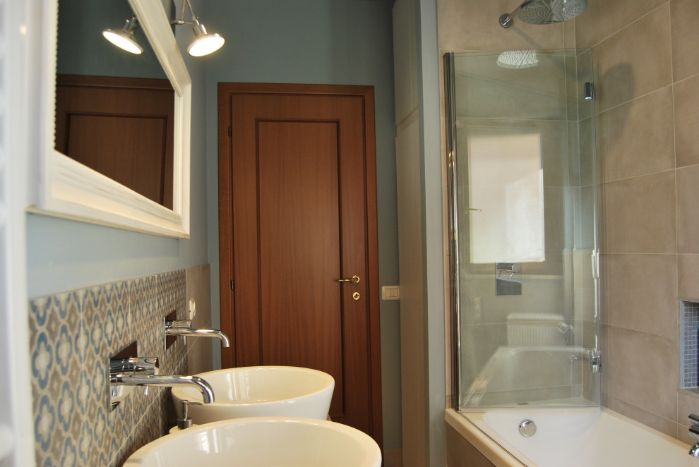 This is an example of a modern bathroom with a two-piece toilet, blue walls, porcelain flooring and a vessel sink.