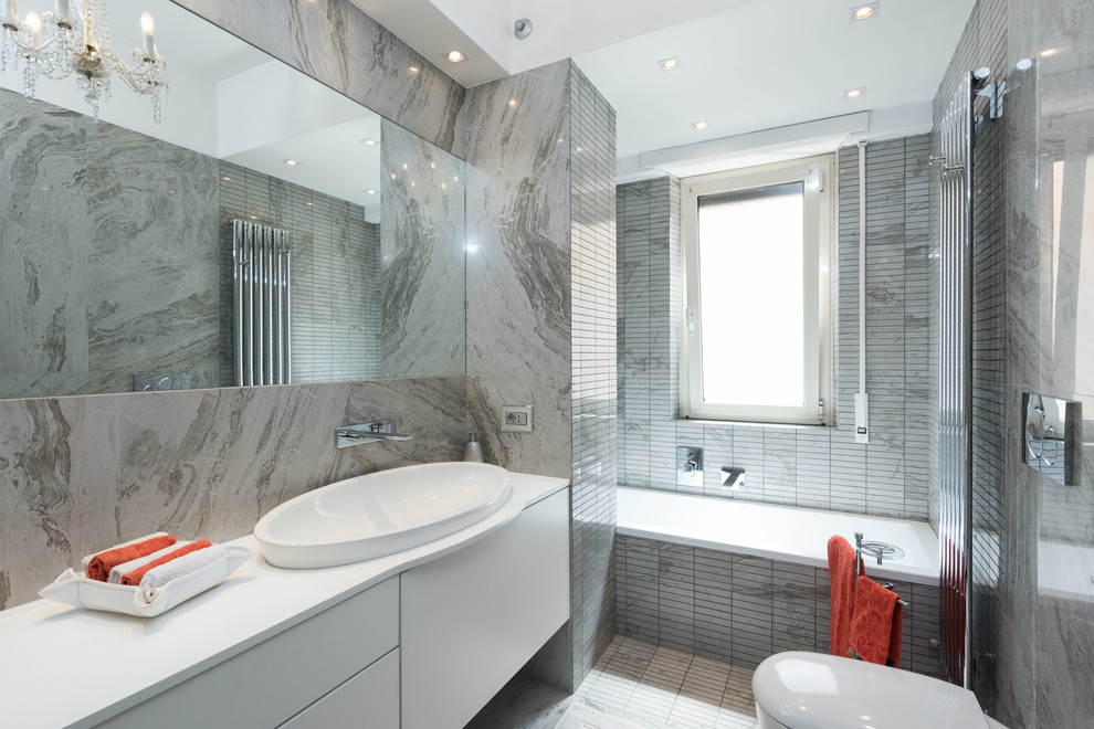 Bild på ett funkis en-suite badrum, med släta luckor, vita skåp, ett platsbyggt badkar, grå kakel, stickkakel, ett nedsänkt handfat och med dusch som är öppen