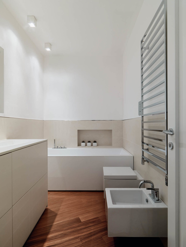 На фото: главная ванная комната среднего размера в современном стиле с плоскими фасадами, бежевыми фасадами, ванной в нише, душем над ванной, биде, темным паркетным полом и открытым душем с