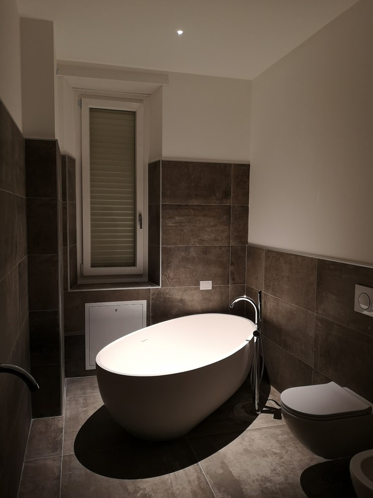 Immagine di una grande stanza da bagno padronale contemporanea con vasca freestanding, WC a due pezzi, piastrelle in gres porcellanato, pareti bianche, pavimento in gres porcellanato e lavabo a bacinella