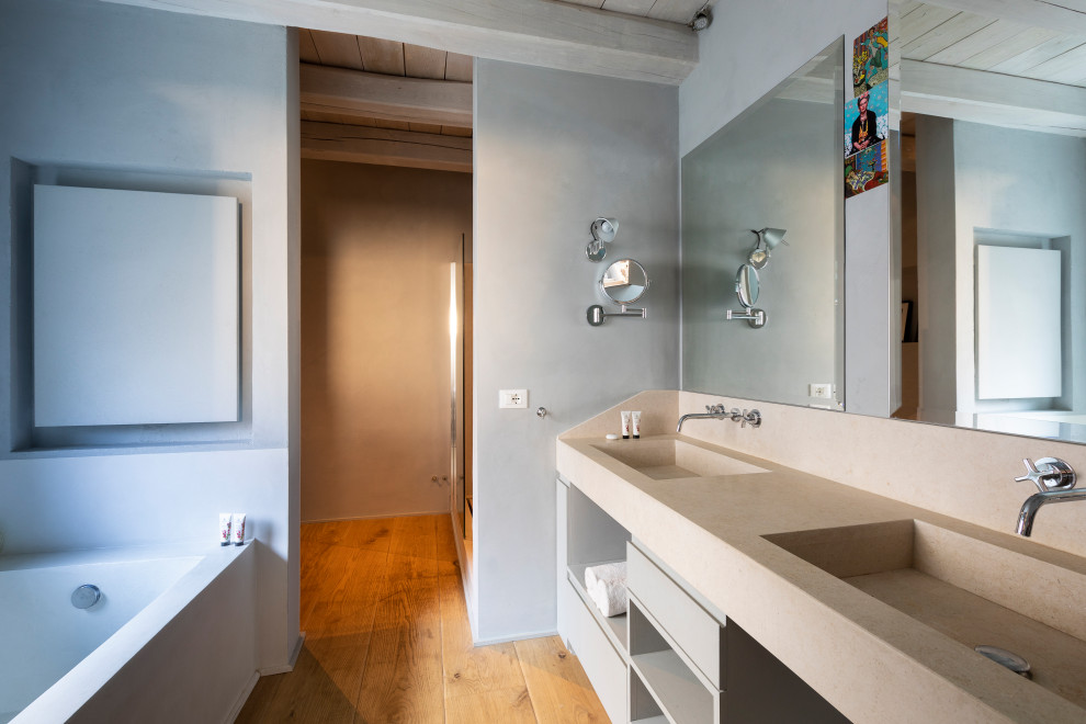 На фото: большая главная ванная комната в средиземноморском стиле с серыми фасадами и тумбой под две раковины с