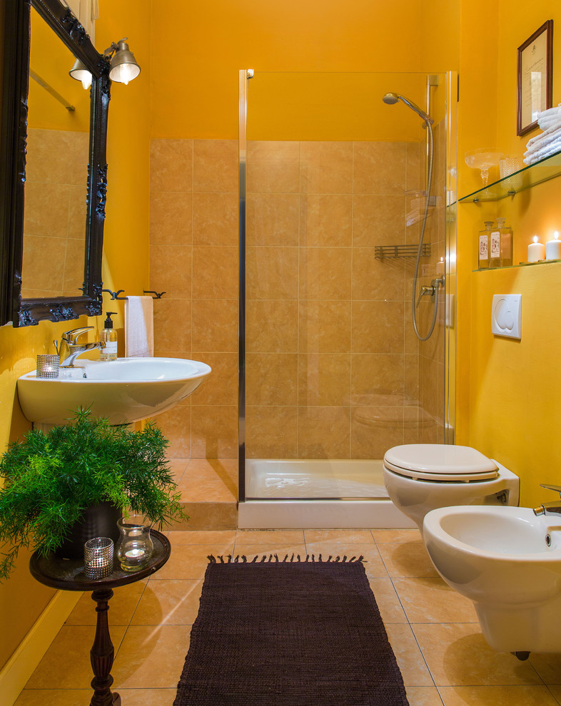 Cette image montre une petite salle d'eau traditionnelle avec une douche ouverte, WC séparés, un carrelage beige, des carreaux en terre cuite, un mur jaune, tomettes au sol, un lavabo suspendu, un sol orange et aucune cabine.