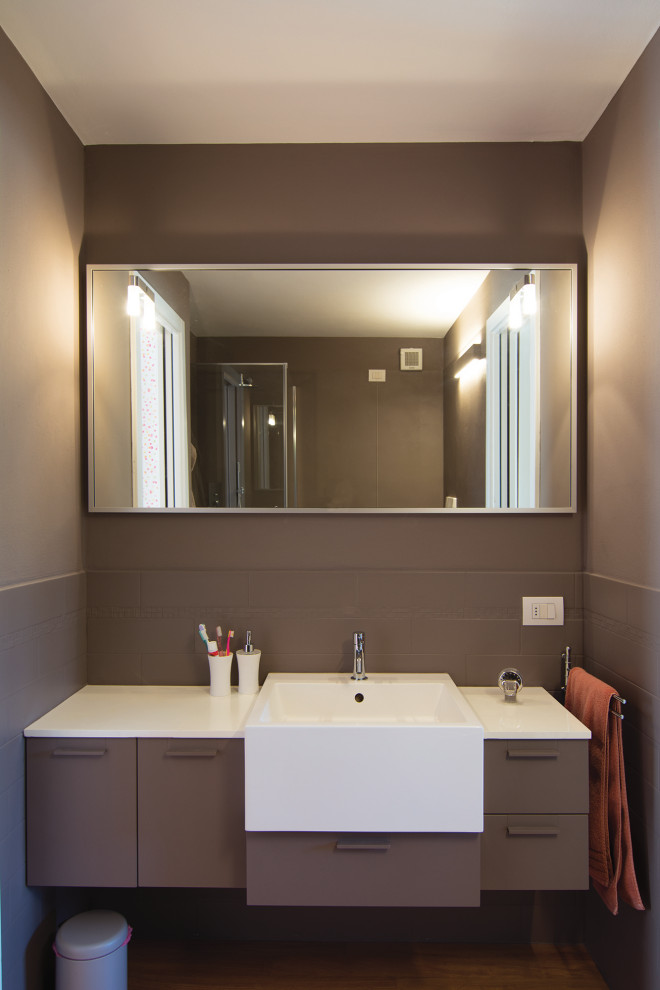 Exempel på ett litet modernt brun brunt badrum med dusch, med släta luckor, bruna skåp, en hörndusch, en toalettstol med separat cisternkåpa, brun kakel, bruna väggar, ljust trägolv, ett nedsänkt handfat, bänkskiva i kvartsit och dusch med gångjärnsdörr