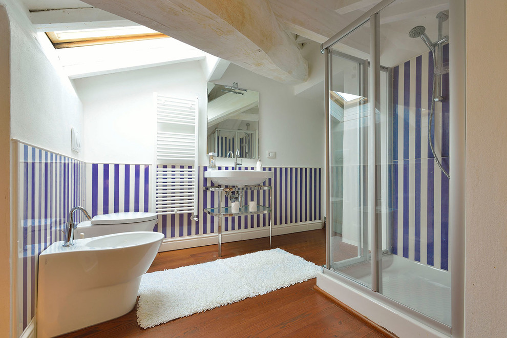 Mediterranes Badezimmer mit Eckdusche, Toilette mit Aufsatzspülkasten, weißer Wandfarbe, dunklem Holzboden und Waschtischkonsole in Florenz