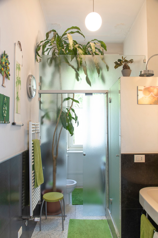 Idee per una stanza da bagno minimalista di medie dimensioni con piastrelle nere, piastrelle in gres porcellanato, pavimento in gres porcellanato, lavabo a consolle, porta doccia a battente, lavanderia e un lavabo
