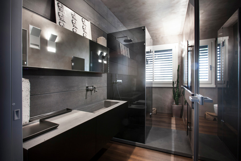 Modelo de cuarto de baño largo y estrecho contemporáneo grande con armarios con paneles lisos, paredes grises, suelo de madera en tonos medios, aseo y ducha y lavabo integrado