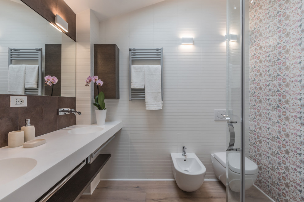 Foto di una stanza da bagno contemporanea con piastrelle multicolore, pavimento in legno massello medio, lavabo integrato, pavimento marrone, top bianco, due lavabi, mobile bagno sospeso e soffitto a volta