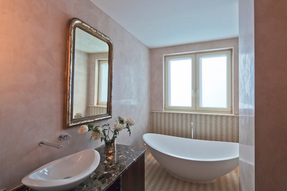 Immagine di una grande stanza da bagno padronale bohémian con ante a filo, ante in legno scuro, vasca giapponese, WC sospeso, pareti rosa, pavimento in pietra calcarea, lavabo a bacinella, top in marmo e pavimento beige
