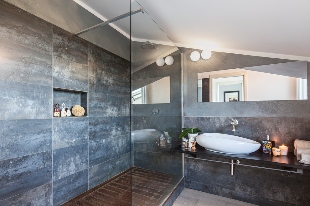 Diseño de cuarto de baño actual de tamaño medio con ducha empotrada, baldosas y/o azulejos grises, paredes grises, aseo y ducha, lavabo sobreencimera, ducha abierta y espejo con luz