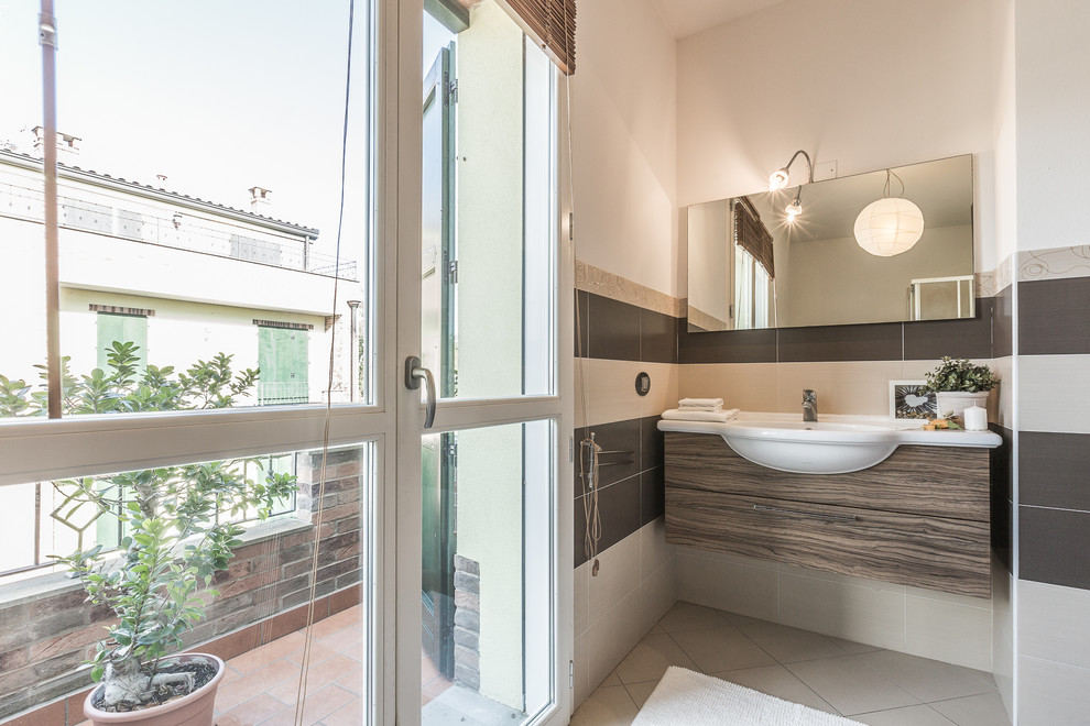 Modernes Badezimmer mit Einbauwaschbecken, flächenbündigen Schrankfronten, dunklen Holzschränken, grauen Fliesen und weißer Wandfarbe in Bologna
