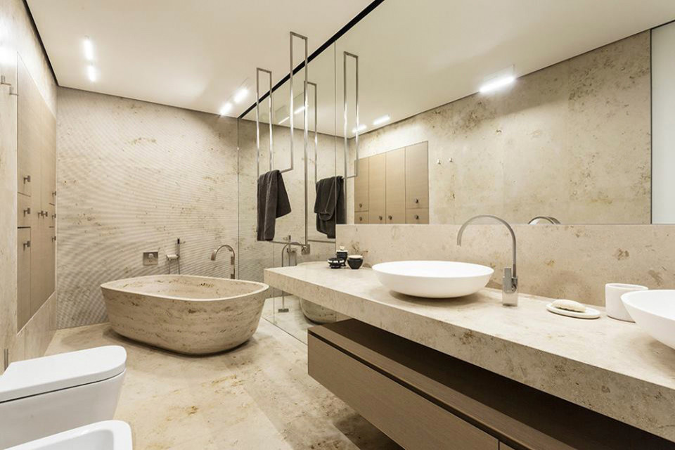 Esempio di una stanza da bagno padronale moderna con vasca freestanding, piastrelle in travertino, pavimento in travertino, lavabo integrato e top in marmo