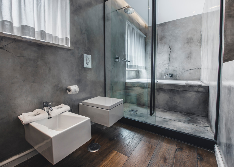 Foto de cuarto de baño urbano de tamaño medio con sanitario de dos piezas, paredes grises, suelo de madera en tonos medios, aseo y ducha y lavabo de seno grande