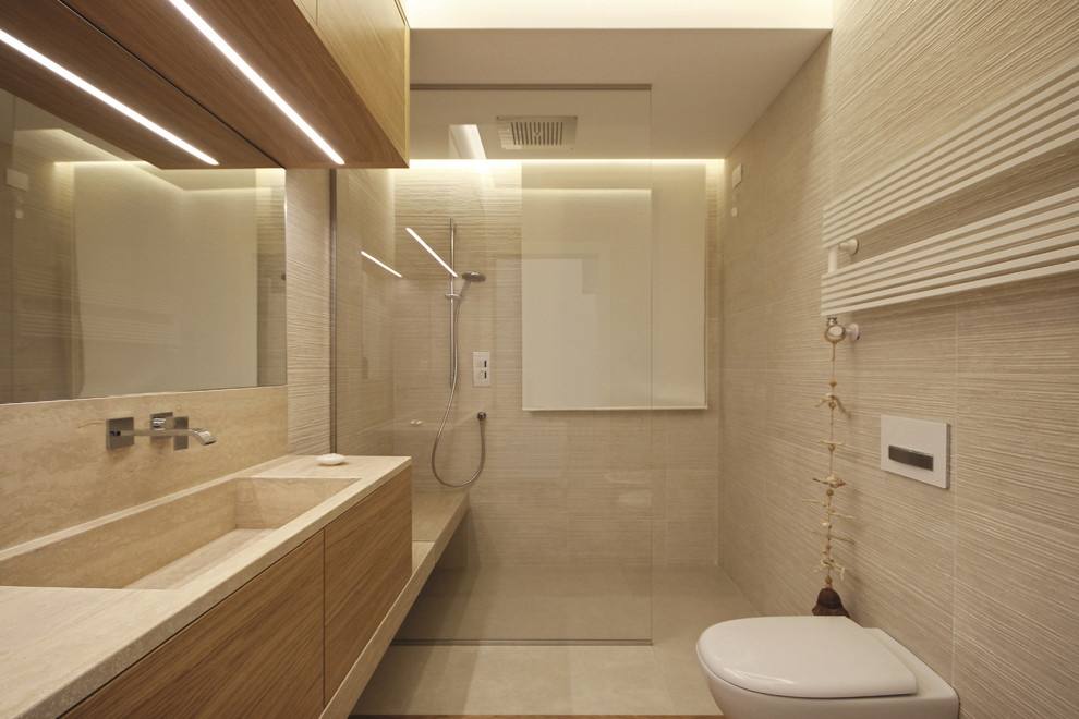 This is an example of a medium sized modern shower room bathroom in Milan with flat-panel cabinets, light wood cabinets, a built-in shower, a wall mounted toilet, beige tiles, porcelain tiles, beige walls, medium hardwood flooring, an integrated sink, marble worktops, beige floors, an open shower and pink worktops.