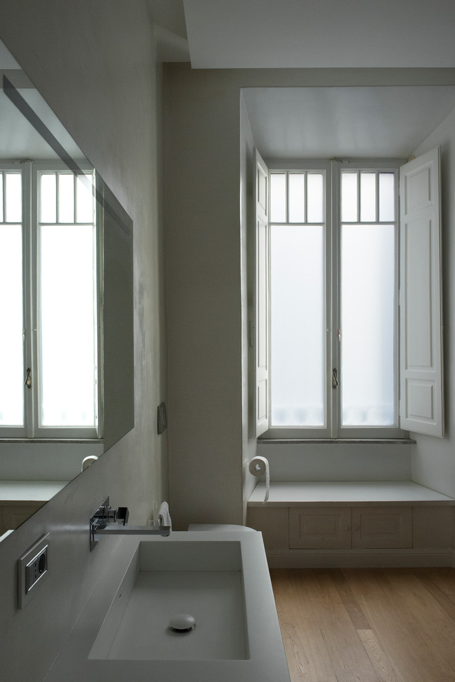 Immagine di una grande stanza da bagno con doccia contemporanea con parquet chiaro, lavabo sospeso, top in superficie solida, top bianco, nessun'anta e pareti grigie
