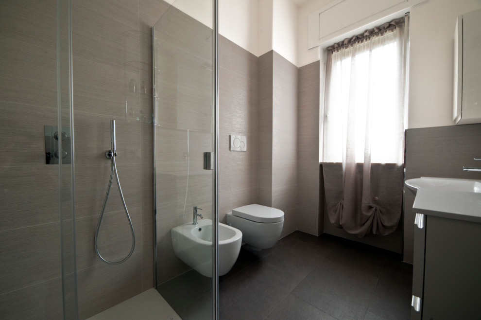 Example of a mid-sized minimalist 3/4 beige tile and porcelain tile porcelain tile and gray floor bathroom design in Other with flat-panel cabinets, gray cabinets, a wall-mount toilet, an integrated sink, solid surface countertops and white countertops