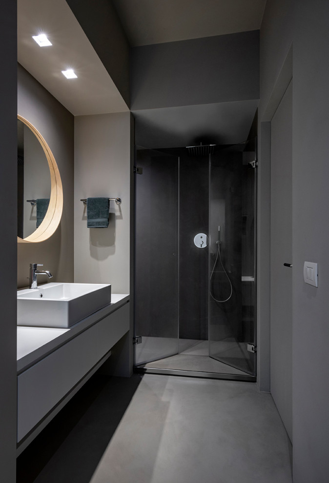 Bild på ett mellanstort funkis grå grått badrum med dusch, med släta luckor, grå skåp, en dusch i en alkov, grå väggar, ett fristående handfat, grått golv och dusch med gångjärnsdörr