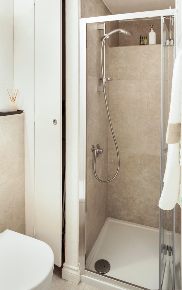 Esempio di una stanza da bagno con doccia stile marinaro con ante beige, doccia alcova, WC sospeso, piastrelle beige, pareti bianche, pavimento in gres porcellanato, top in superficie solida, pavimento beige e top beige